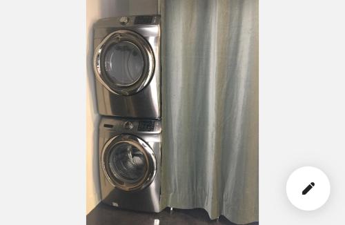 a washer and dryer sitting next to a curtain at Petaluma Warehouse Lofts unit E in Petaluma