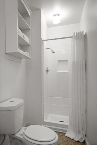 a white bathroom with a toilet and a shower at Inn at Sugar Pine Ranch in Groveland