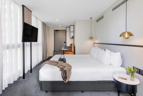 a hotel room with a bed and a flat screen tv at Brady Hotels Jones Lane in Melbourne