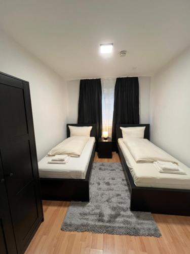 a room with two beds and a window at E & N Apartments in Oberhausen