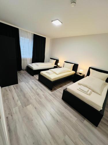 two beds in a room with wooden floors at E & N Apartments in Oberhausen
