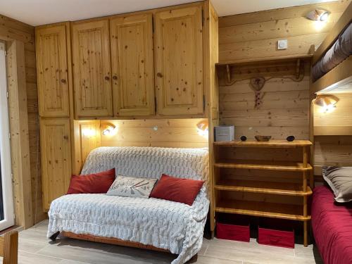 een slaapkamer met houten wanden en een bank in een kamer bij Carène in Valloire