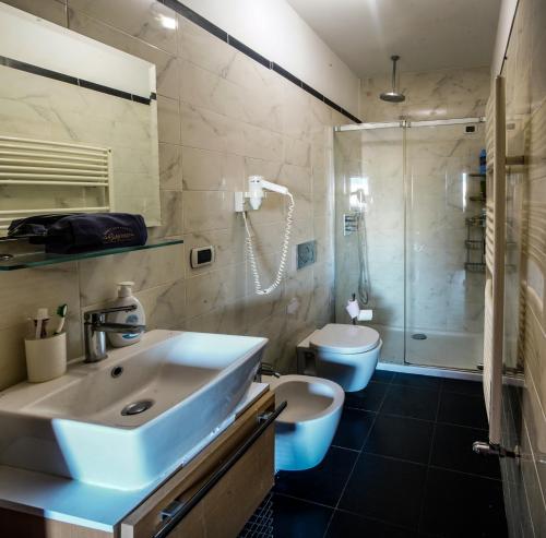 een badkamer met een wastafel, een toilet en een douche bij Suite de Roland in Taormina
