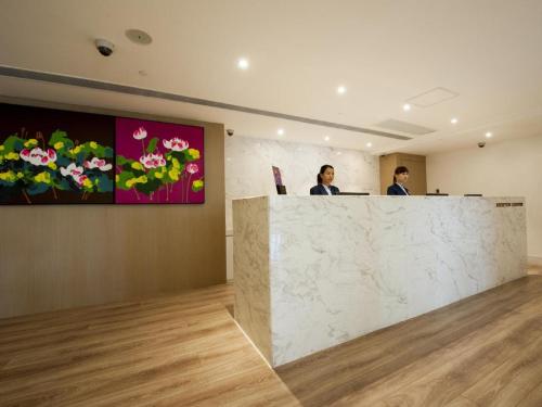 two men sitting at a reception counter in a room at Inn Hotel Macau in Macau