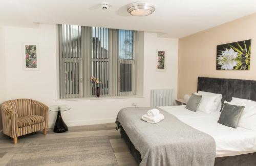 a hotel room with two beds and a chair at Cozy Studio Flat for Rent in Preston