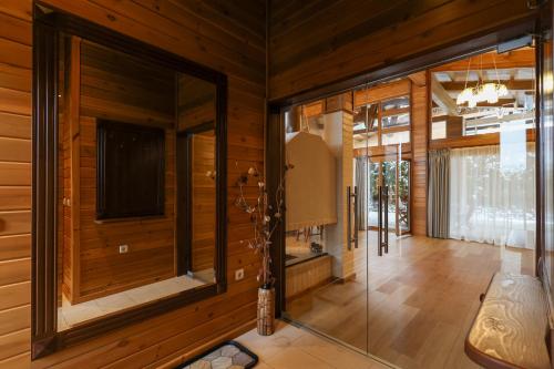 Cette chambre est dotée de murs en bois et d'une porte en verre. dans l'établissement Villa Katerina Deluxe - Pirin Golf and Country Club, à Bansko