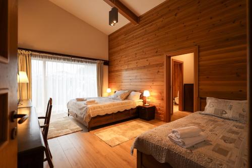 a bedroom with two beds and a window at Villa Katerina Deluxe - Pirin Golf and Country Club in Bansko