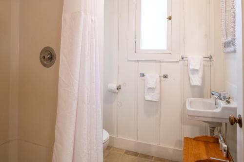 a bathroom with a white shower curtain and a sink at Inn at Sugar Pine Ranch in Groveland