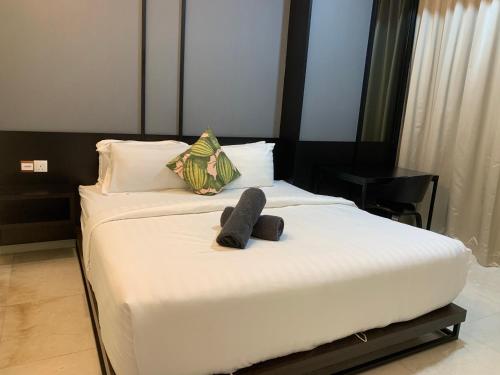 um quarto com uma cama com dois chinelos em Tropicana The Residences By RS em Kuala Lumpur