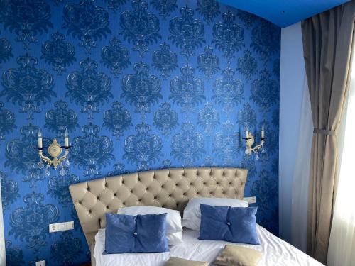 a blue bedroom with a bed with a blue wall at Casa Dunarea by Genco in Predeal