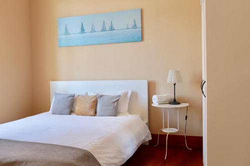 1 dormitorio con cama blanca y veleros en la pared en LX Factory guest house en Lisboa