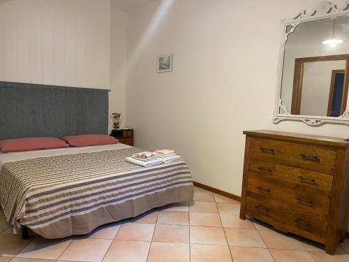 a bedroom with a bed and a mirror and a dresser at Pà Blanc Apartments in Alghero
