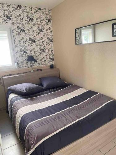 une chambre avec un lit et un miroir au mur dans l'établissement Maison avec terrasse et jardin à 600m de la plage, à Berck-sur-Mer