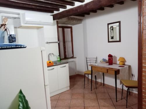 eine Küche mit einem Tisch, einem kleinen Tisch und Stühlen in der Unterkunft Camera Vacanze Lusitana C in Foligno
