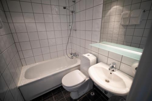 a white bathroom with a toilet and a sink at Stryn Hotel in Stryn