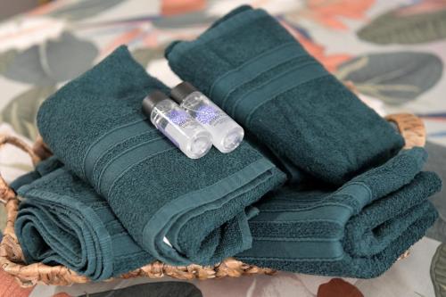 a wicker basket with green towels and two bottles at Ammos studio Loutraki in Loutraki