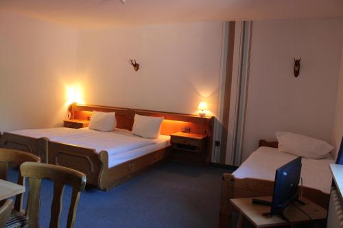 Habitación de hotel con 2 camas, mesa y sillas en Berggasthof Hoherodskopf, en Schotten