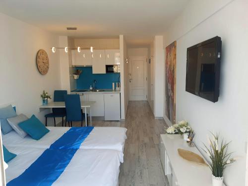 1 dormitorio con 1 cama azul y blanca y cocina en Las Americas Best-Suite 10 -Studio Luxury con vista a 5 mins dalla spiaggia con 2 piscine en Playa Fañabe