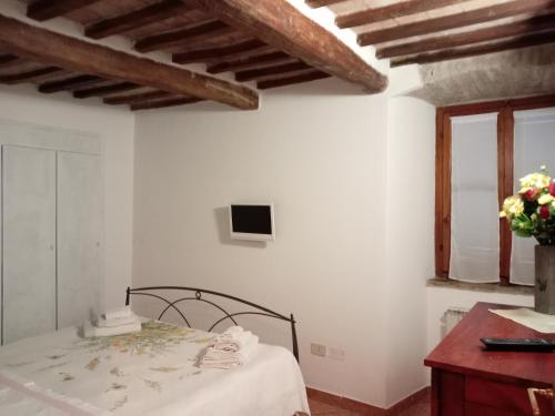ein weißes Zimmer mit einem Bett und einem Fenster in der Unterkunft Camera Vacanze Lusitana C in Foligno