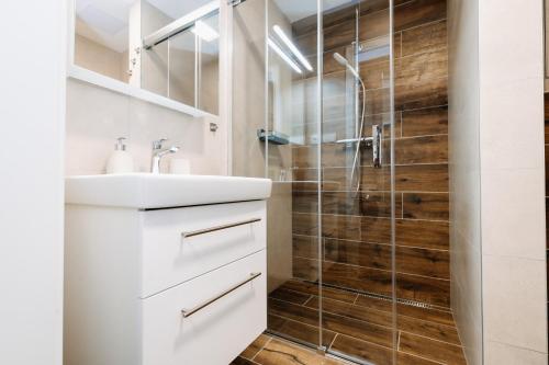 a bathroom with a white sink and a shower at Horský apartmán Temari 14 Klínovec in Loučná pod Klínovcem