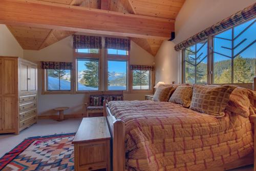 a bedroom with a bed in a room with windows at Sundance Lodge -Mountain Home w Views of Palisades - Ski Shuttle, Pets okay! in Olympic Valley