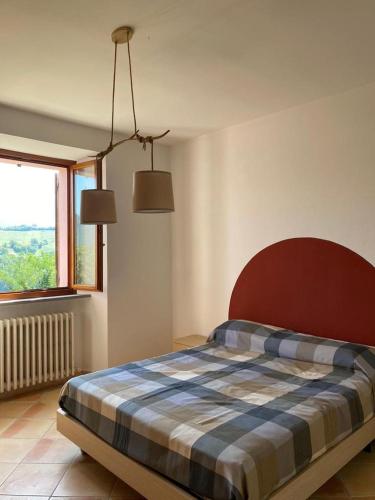 - une chambre avec un lit et une couverture en damier dans l'établissement Tenuta Frasassi, à Collegiglioni