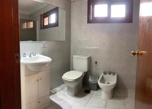 uma casa de banho com um WC e um lavatório em Bagu Pinamar Hotel em Pinamar