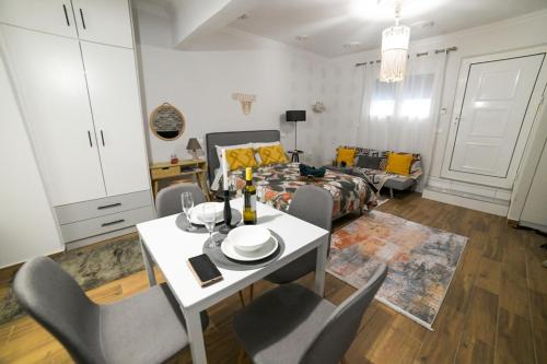 un soggiorno con tavolo, sedie e un letto di Ammos studio Loutraki a Loutraki