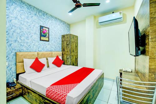 盧迪亞納的住宿－OYO Hotel Grace Villa，一间卧室配有一张带红色枕头的床和一台电视。