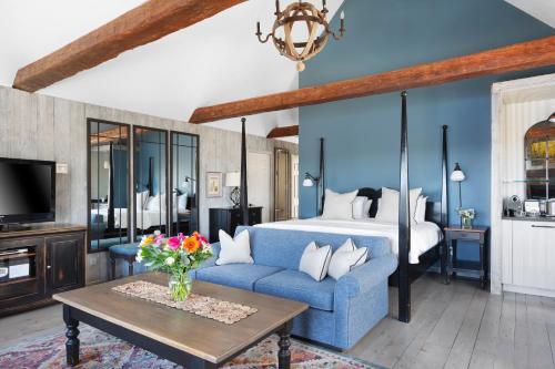 a living room with a blue couch and a bed at Manoir Hovey, Relais & Châteaux in North Hatley