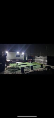 a tennis court is lit up at night at كرفانات الدار in Ras al Khaimah