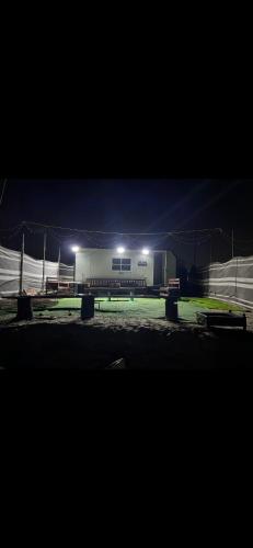 a building with two benches in front of it at night at كرفانات الدار in Ras al Khaimah