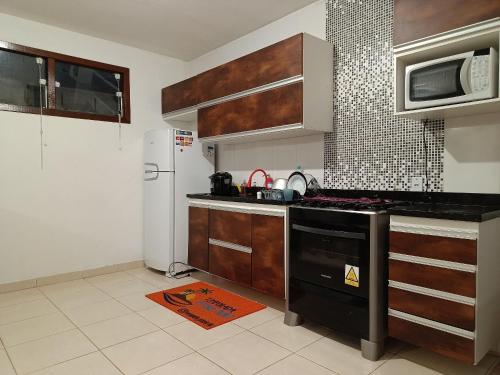 a kitchen with a stove and a refrigerator at Casa Temporada peterle Iriri in Iriri