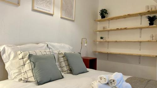 a bedroom with a bed with pillows and shelves at Le refuge de velours in Nevers