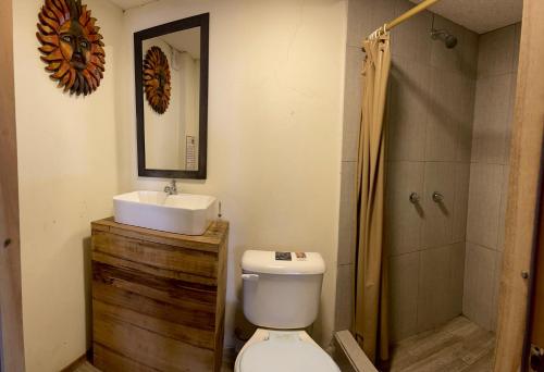 y baño con aseo, lavabo y ducha. en Aloha.ayampe, en Ayampe