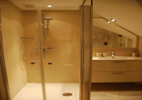 una doccia con una porta in vetro in un bagno di Hotel Rubens a De Haan