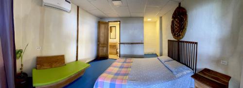 アヤンペにあるAloha.ayampeの小さなベッドルーム(ベッド1台、緑のベッドバイザー付)