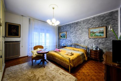 a bedroom with a bed and a table at Rètro Apartment In The Mountains in Mezzolombardo