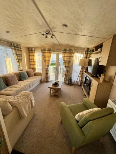 a living room with a couch and a chair at Bayview Bliss - Holiday Caravan in Newbiggin by the Sea - Northumberland in Newbiggin-by-the-Sea