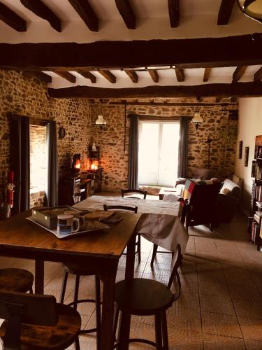 un salon avec une table et des chaises en bois dans l'établissement Chambres d'Hôtes Bastia et Bonifacio, à Retiers