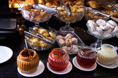 a table topped with plates of pastries and desserts at Foz Plaza Hotel in Foz do Iguaçu
