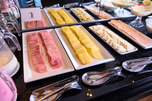 a buffet filled with different types of meats and cheese at Foz Plaza Hotel in Foz do Iguaçu