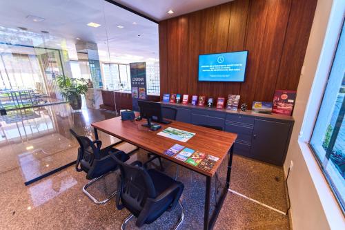 an office with a table and chairs and a tv at Foz Plaza Hotel in Foz do Iguaçu