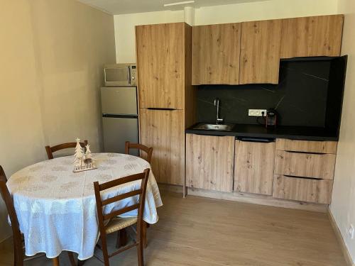 une cuisine avec une table et des chaises ainsi qu'une télévision dans l'établissement Le Veymont Élégance Montagnarde, à Villard-de-Lans