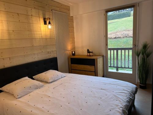 Un dormitorio con una cama grande y una ventana en Le Veymont Élégance Montagnarde, en Villard-de-Lans