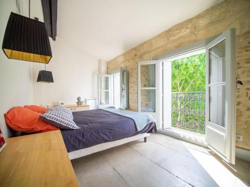 a bedroom with a bed and a large window at Le Platane de la canourgue in Montpellier