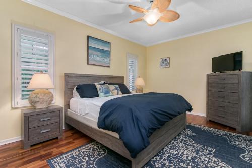a bedroom with a bed and a ceiling fan at Private Heated Pool & Beach House in Vero Beach