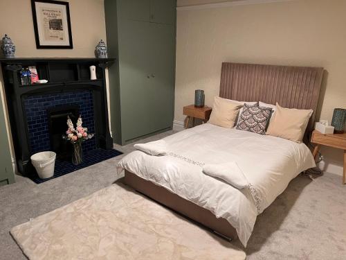 een slaapkamer met een bed en een open haard bij Luxury Cosy Retreat Apt in Londen