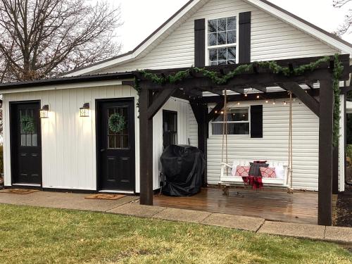 a white house with a pergola on a deck at Farmhouse of Blessings in Dundee