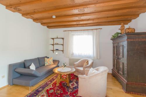 a living room with a blue couch and a table at Landhaus Tritscher in Schladming